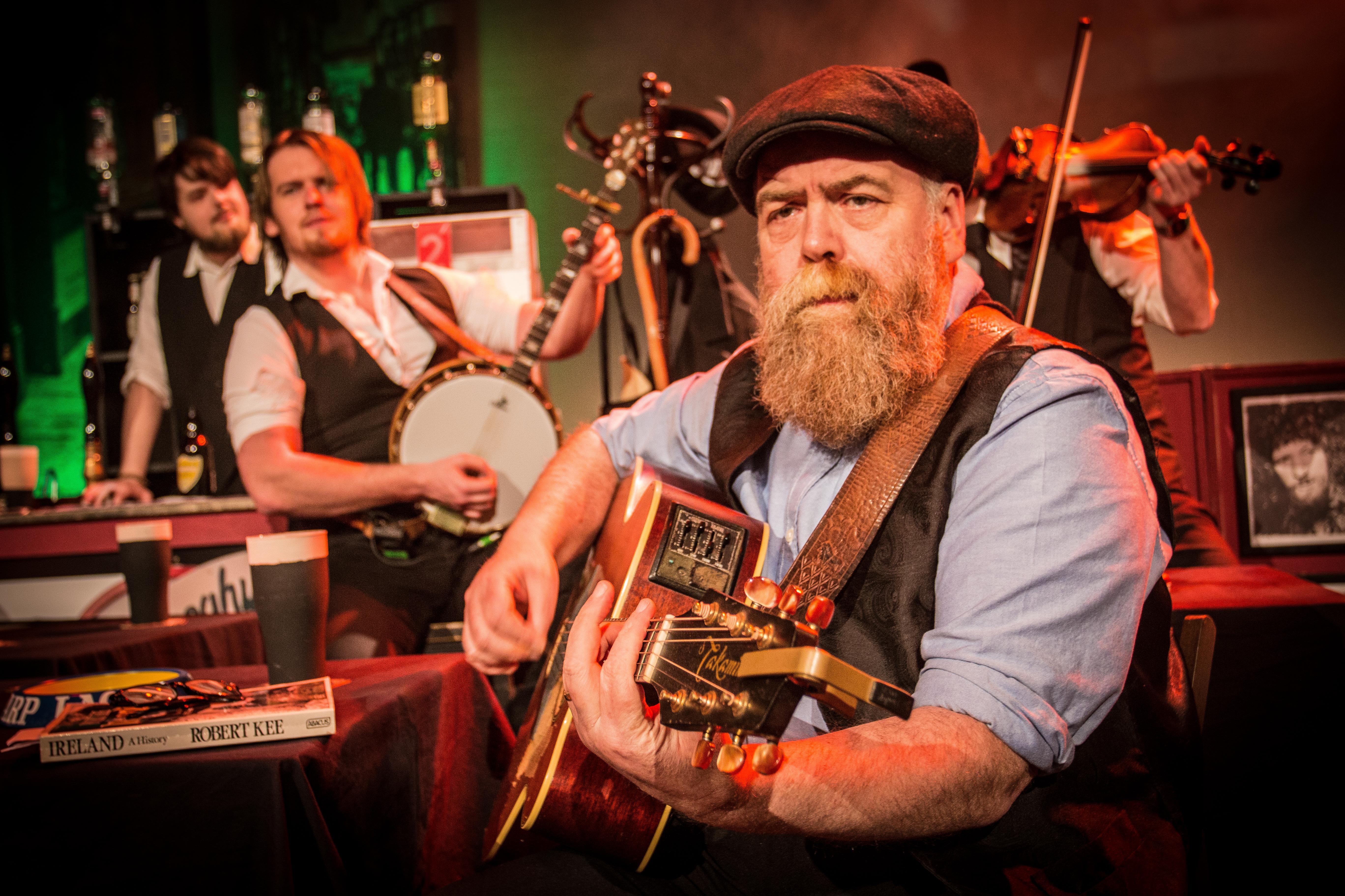 Man with beard playing the guitar