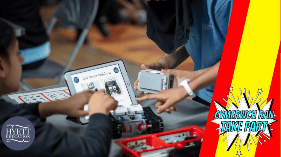 two boys work on a robotics and coding kit around a table.there's a silver electronic tablet in the middle of the table