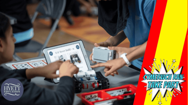 two boys work on a robotics and coding kit around a table.there's a silver electronic tablet in the middle of the table